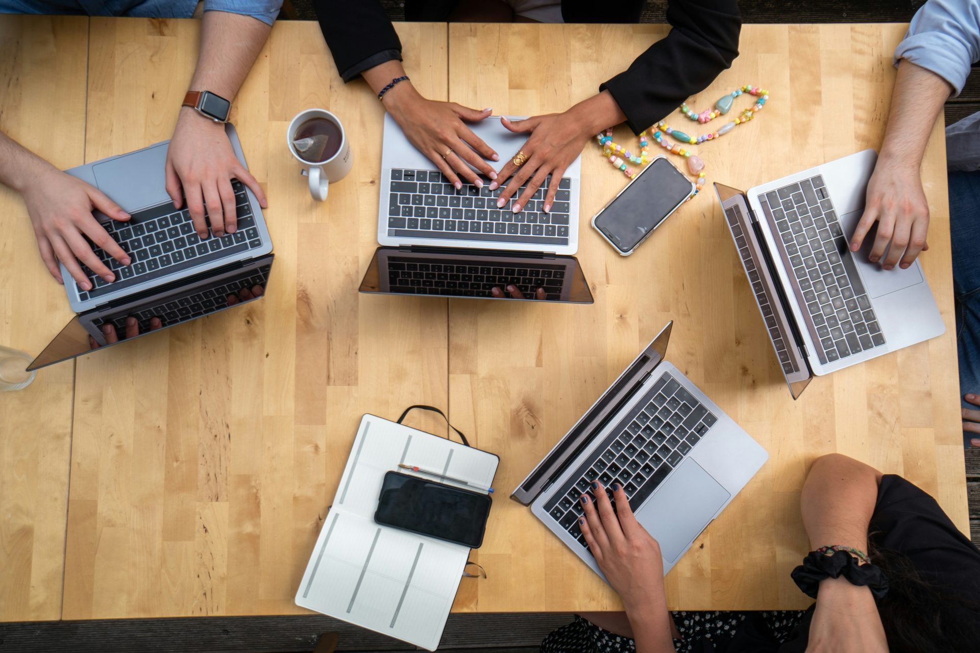personne utilisant un MacBook Pro sur une table en bois marron